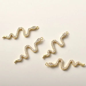 Detailansicht von vier 14k vergoldeten Schlangenanhängern mit Zirkonia für DIY-Schmuck