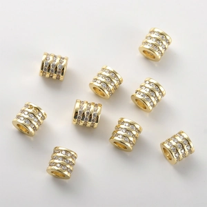 Dettaglio macro di 9 perle placcate in oro 14k con zirconi per la creazione di gioielli fai da te