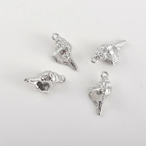 Vue détaillée de quatre pendentifs conque argentés polis pour création de bijoux
