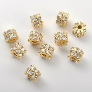 Vista dettagliata di perle a barilotto placcate oro 14k con zirconi incastonati per DIY