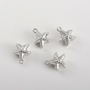Détail de quatre pendentifs étoile de mer argentés avec texture et anneaux pour bijoux DIY