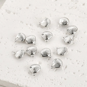 Détails macro de breloques en coquillage argenté pour la création de bijoux DIY raffinés