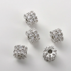 Dettaglio macro di perline a tubo con zirconi micro-pave per creazione gioielli DIY