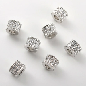 Macro shot of 14k gold-plated barrel beads with micro-pave cubic zirconia and milgrain edges