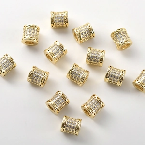 Macro shot of 14k gold plated cylinder beads with micro-paved cubic zirconia details