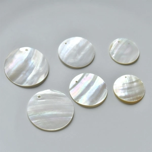 Close-up of circular natural mother of pearl shell pendants with pre-drilled holes
