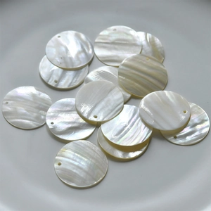 Macro shot of natural round mother of pearl shell charms with iridescent luster for DIY jewelry