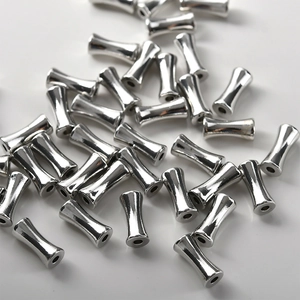 Vue macro de perles tubes en bambou argenté poli pour la création de bijoux DIY créatifs