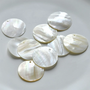 Macro view of flat round natural mother of pearl shell pendants with iridescent white luster