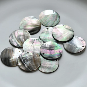 Macro shot of natural iridescent seashell round pendants for DIY jewelry making