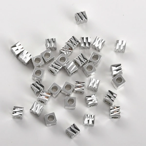 Macro-opname van verzilverde vierkante kralen met diamantgeslepen facetten voor DIY sieraden