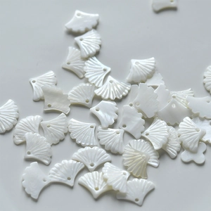 Makro-Detail von natürlichen Perlmutt-Ginkgoblatt-Anhängern mit Perlglanz-Textur und Glanz