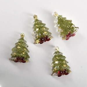 Dettaglio di ciondoli a forma di albero di Natale in resina con foglie verdi e fiocchi