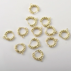 Detalle macro de componentes de pendientes de cuerda trenzada bañados en oro de 14k
