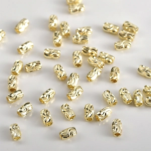 Macro shot of 14k gold-plated cylinder beads with spiral wave texture for DIY jewelry