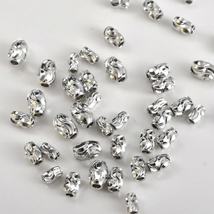 Detailed view of silver-plated spiral water wave rice beads for DIY jewelry making