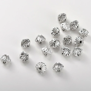 Macro detail of textured silver spacer beads with radial ridges for DIY jewelry making