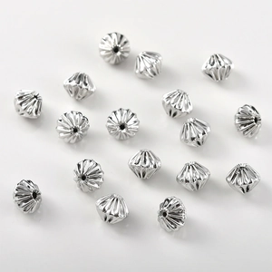 Macro shot of silver plated pumpkin shaped spacer beads with radial texture for DIY jewelry
