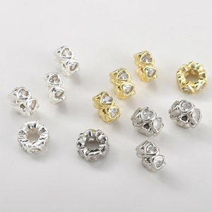 Macro detail of heart-shaped 14k gold plated spacer beads with sparkling zircon stones
