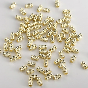Macro detail of 14k gold-plated barrel beads with textured vertical lines for DIY jewelry