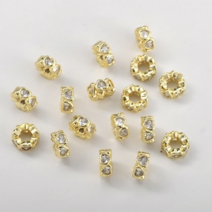 Macro view of 14k gold-plated heart-shaped spacer beads with cubic zirconia for DIY jewelry