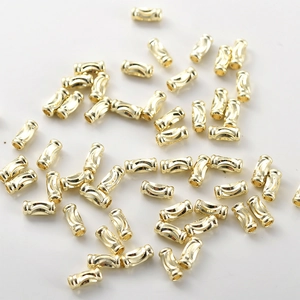 Macro shot of 14k gold-plated hollow spacer beads with grooved texture for DIY jewelry making