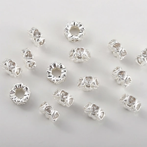 Close-up of heart and flower spacer beads with cubic zirconia for DIY jewelry making