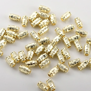 Macro detail of 14k gold plated cylinder beads with concave pattern for DIY jewelry
