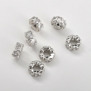 Detail of silver heart-shaped spacer beads with cubic zirconia for DIY jewelry