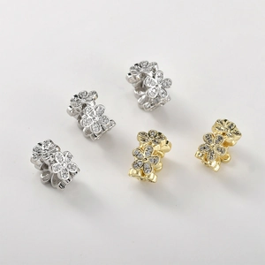 Macro detail of S925 silver floral spacers with gold plating and cubic zirconia inlay