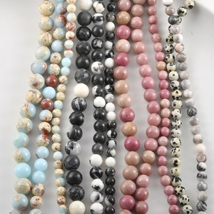 Vertical rows of natural stone beads including marble pattern and spotted gemstones