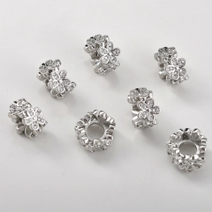 Macro shot of silver flower spacer beads with white cubic zirconia for jewelry making