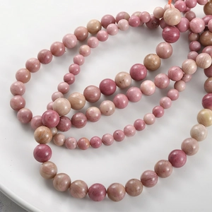 Macro view of natural pink spotted stones with marbled texture on a white plate