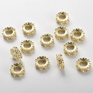 Macro view of 14k gold plated clover spacer beads with sparkling zircon for DIY jewelry
