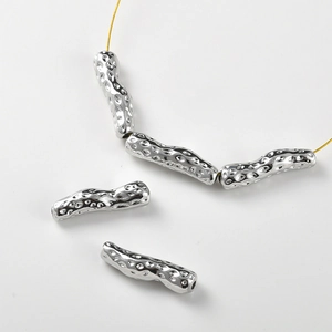 Macro shot of silver baroque textured tube beads for DIY jewelry making material
