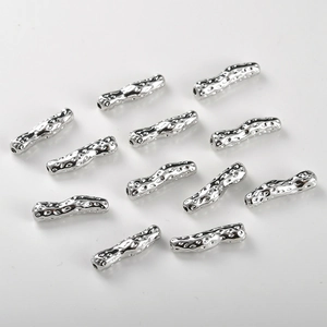 Macro view of silver hammered textured curved tube beads for DIY jewelry making and crafts