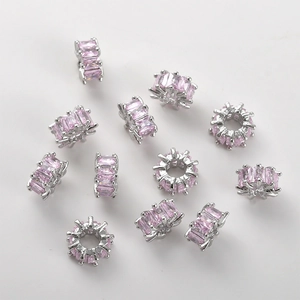 Detailed macro view of 14k gold-plated spacer beads with pink cubic zirconia stones