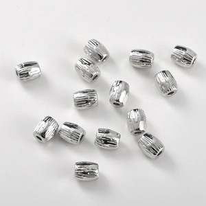 Textured silver cylinder spacer beads for DIY jewelry making on white background