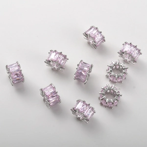 Macro detail of 14k gold plated spacer beads with pink zircon inlay for jewelry making