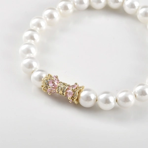 Elegant 14k gold plated pearl bracelet with pink zircon bow clasp and shiny stones