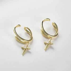Macro-opname van 14k vergulde oormanchetten met stervormige hangers en kleine zirkonia's