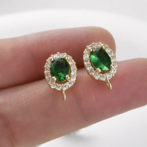 Macro view of emerald green oval halo earring charms with 14k gold plated base