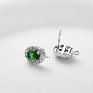 Detailed view of S925 silver stamp on oval emerald earrings with zircon halo and loops