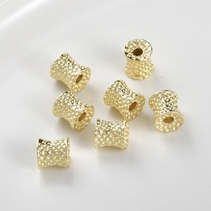 Macro shot of 14k gold-plated textured spacer beads with honeycomb patterns for DIY jewelry