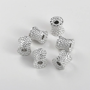 Macro detail of silver hammered metal beads with a textured finish for jewelry making