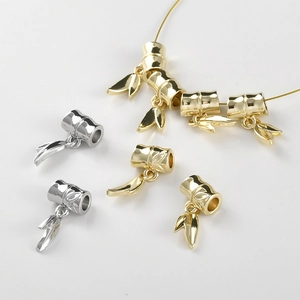 Detailed view of bamboo-shaped jewelry pendants in gold and silver finish for DIY crafts