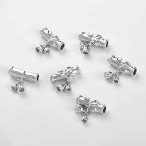 Detailed view of silver bamboo-style curved tube charms with lily bell pendants for DIY