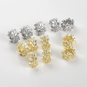Makro-Detail von hohlen 14k Gold- und Silberblumenperlen für DIY-Schmuckherstellung