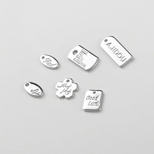 Macro detail of silver-plated copper flower tags and oval pendants for DIY jewelry