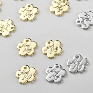 Detailed macro view of gold and silver flower metal tags engraved with Hand Made text